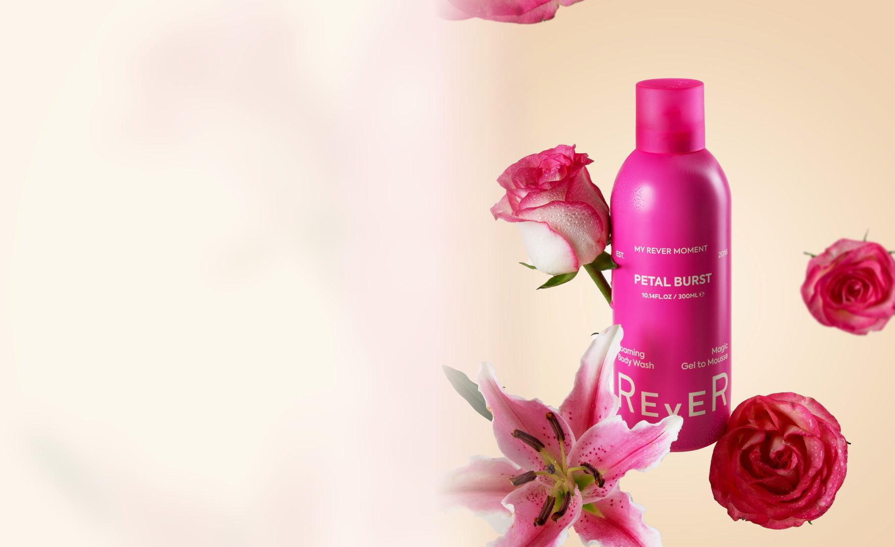 REVER Petal Burst foaming body wash styled with fresh flowers in a clean studio scene